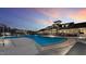 Community pool at dusk, featuring a large pool area, pool house, lounge chairs, and beautiful building at 244 Mahogany Run, Raleigh, NC 27610