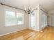 Bright dining room featuring hardwood floors, a modern chandelier, and large windows at 27 Kings Mount Ct, Durham, NC 27713