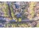 Overhead view of the property featuring a house, road access, and verdant trees at 3012 Optimist Farm Rd, Apex, NC 27539