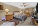 Comfortable bedroom featuring a ceiling fan, dresser with mirror, and cozy plaid blanket on the bed at 3012 Optimist Farm Rd, Apex, NC 27539