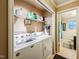 Efficient laundry room with overhead shelving, adjacent to bathroom, offering convenience and functionality at 3012 Optimist Farm Rd, Apex, NC 27539