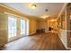 Spacious living room with warm wood flooring and double doors opening to the exterior at 3012 Optimist Farm Rd, Apex, NC 27539