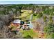 Expansive aerial view of a stunning property with a large house, manicured lawn, and surrounding woodland at 3227 Morrow Farm Ln, Chapel Hill, NC 27516