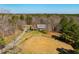Aerial view of a cozy home with a long driveway amid a wooded landscape at 3227 Morrow Farm Ln, Chapel Hill, NC 27516