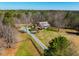 Aerial view revealing the home's layout, circular driveway, picturesque setting, and surrounding natural beauty at 3227 Morrow Farm Ln, Chapel Hill, NC 27516