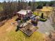 Aerial view of red home with a stone fireplace, patio, and long gravel driveway at 3227 Morrow Farm Ln, Chapel Hill, NC 27516