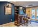 Finished basement bar area with a dark wood bar, seating, and dark blue walls at 3227 Morrow Farm Ln, Chapel Hill, NC 27516