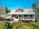 Charming two-story home with a metal roof, covered front porch, manicured lawn and mature landscaping at 3227 Morrow Farm Ln, Chapel Hill, NC 27516