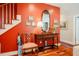 Foyer featuring red accent wall, hardwood floors, ornate chair, and decoratively styled table at 3227 Morrow Farm Ln, Chapel Hill, NC 27516