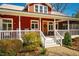 Inviting front porch with rocking chairs, complemented by lush greenery and a charming entrance at 3227 Morrow Farm Ln, Chapel Hill, NC 27516