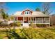 Charming front view of a red home with a welcoming porch and beautifully landscaped yard at 3227 Morrow Farm Ln, Chapel Hill, NC 27516