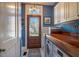 Charming mud room features a wood door, detailed tile flooring and a wood countertop over washer and dryer at 3227 Morrow Farm Ln, Chapel Hill, NC 27516