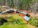 Aerial view of multiple outbuildings with red siding and metal roofs on a large grassy lawn surrounded by a split rail fence at 3227 Morrow Farm Ln, Chapel Hill, NC 27516