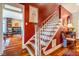 A staircase with hardwood steps, white risers, and a red accent wall, with a view into another room at 3227 Morrow Farm Ln, Chapel Hill, NC 27516