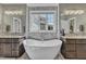Bright bathroom with freestanding tub, dual sinks and vanities, and decorative tile accents at 3240 Donlin Dr, Wake Forest, NC 27587