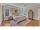 Primary bedroom featuring tray ceiling, hardwood floors, large windows, and neutral color palette at 3240 Donlin Dr, Wake Forest, NC 27587