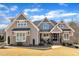 Charming two-story home featuring stone accents, a well-manicured lawn, and craftsman-style architectural details at 3240 Donlin Dr, Wake Forest, NC 27587