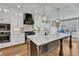 Bright kitchen with granite counters, stainless appliances, custom range hood and hardwood flooring at 3240 Donlin Dr, Wake Forest, NC 27587