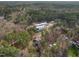 Aerial view of gray house nestled in wooded area with a modern building in the background at 3541 Rugby Rd, Durham, NC 27707