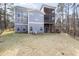 Backyard view of a blue two-story home with decks, multiple windows, and an irrigation system at 3541 Rugby Rd, Durham, NC 27707