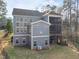 Backyard view of a blue two-story home with decks, multiple windows, and an irrigation system at 3541 Rugby Rd, Durham, NC 27707