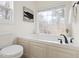 Bathroom with tub, window, and white toilet at 3541 Rugby Rd, Durham, NC 27707