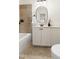 Stylish bathroom featuring a modern vanity, large mirror, and decorative tile surrounding the tub at 3541 Rugby Rd, Durham, NC 27707