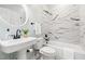 Modern bathroom with a pedestal sink, tiled walls, and a bathtub/shower combination, providing a clean aesthetic at 3541 Rugby Rd, Durham, NC 27707