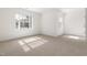 Sunlit bedroom with neutral carpet and two windows at 3541 Rugby Rd, Durham, NC 27707