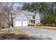 Two-story home featuring a two-car garage, covered front porch, and long driveway in a treed neighborhood at 3541 Rugby Rd, Durham, NC 27707