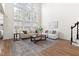 Bright living room with floor to ceiling windows, hardwood floors, and stairs to the upper level at 3541 Rugby Rd, Durham, NC 27707