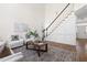 Bright living room features a staircase to the upper level and comfortable white furniture at 3541 Rugby Rd, Durham, NC 27707