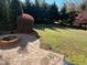 Landscaped backyard featuring a brick fire pit and lush greenery at 3709 Valley Pine Ct, Wendell, NC 27591