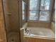 A soaking tub and glass enclosed shower are illuminated by a window in this bathroom at 3709 Valley Pine Ct, Wendell, NC 27591