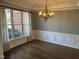 Bright dining room with rich hardwood floors, decorative wainscoting, and a large window with view of brick home at 3709 Valley Pine Ct, Wendell, NC 27591