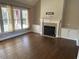 Inviting living room with hardwood floors, a cozy fireplace, built-in cabinets, and large windows for ample light at 3709 Valley Pine Ct, Wendell, NC 27591