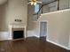 Spacious living room with a fireplace, vaulted ceiling, hardwood floors, and built-in cabinets for extra storage at 3709 Valley Pine Ct, Wendell, NC 27591