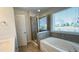 Bathroom featuring a glass shower, soaking tub, and large window for natural light at 49 W Copenhaver Dr, Clayton, NC 27527