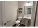 Cozy half bath with a pedestal sink, floating shelves and modern fixtures at 49 W Copenhaver Dr, Clayton, NC 27527
