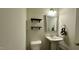 Cozy half bathroom features pedestal sink, decor shelving and decorative mirror at 49 W Copenhaver Dr, Clayton, NC 27527