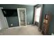 Bedroom featuring carpet floors, a large window, and dark green accent wall at 49 W Copenhaver Dr, Clayton, NC 27527