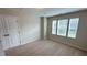 Bright bedroom featuring plush carpet, three windows, and a spacious closet at 49 W Copenhaver Dr, Clayton, NC 27527