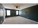 Spacious bedroom features neutral carpet, ceiling fan, and ample natural light from two large windows at 49 W Copenhaver Dr, Clayton, NC 27527