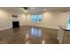 Open-concept living room with hardwood floors, fireplace, and natural light from large windows at 49 W Copenhaver Dr, Clayton, NC 27527