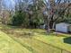 Fenced backyard featuring a lawn, mature trees, and two storage sheds at 5108 Melbourne Rd, Raleigh, NC 27606