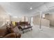 Finished basement with neutral carpet, support beams, brown couches, and a coffee table at 5108 Melbourne Rd, Raleigh, NC 27606