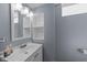 A bathroom with a white sink vanity with open storage and a large mirror on the back wall at 5108 Melbourne Rd, Raleigh, NC 27606