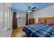 Bright bedroom with blue ceiling, hardwood floors, built-in closet, and a large window at 5108 Melbourne Rd, Raleigh, NC 27606