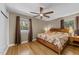 A naturally lit bedroom boasts wood floors, two windows with views, and a warm color palette at 5108 Melbourne Rd, Raleigh, NC 27606
