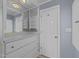 White closet with built-in drawers, shelving, vanity mirror, and a door leading to another room at 5108 Melbourne Rd, Raleigh, NC 27606